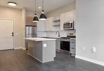 A modern kitchen with a stainless steel refrigerator and a microwave above the stove.