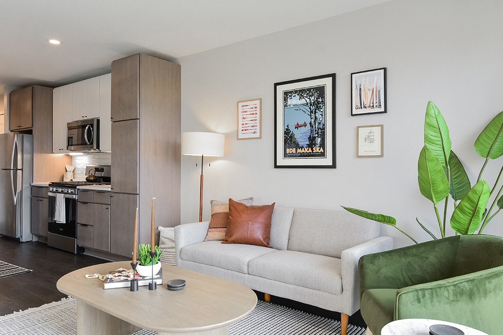 A living room with a grey couch, a coffee table, and a green armchair.