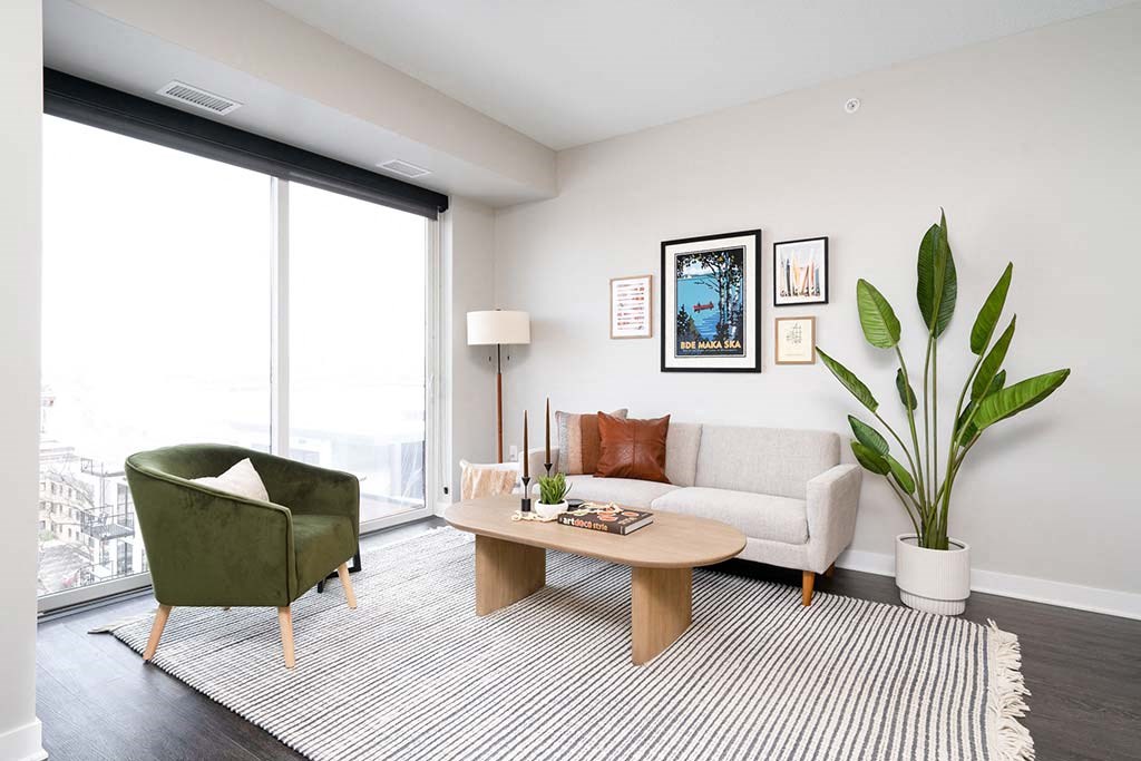 A living room with a green chair, a white couch, and a coffee table.