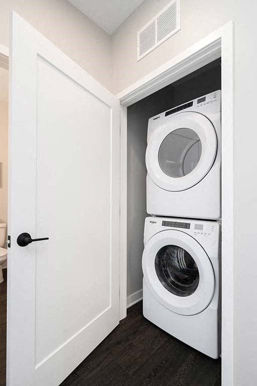 A white door opens to a small laundry room with a washer and dryer.