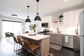 A modern kitchen with a dining table and chairs.