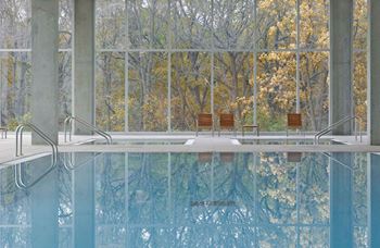 An indoor pool with glass windows at Optima Old Orchard Woods luxury apartments in North Chicago