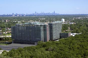 A large building with a lot of windows is surrounded by trees.