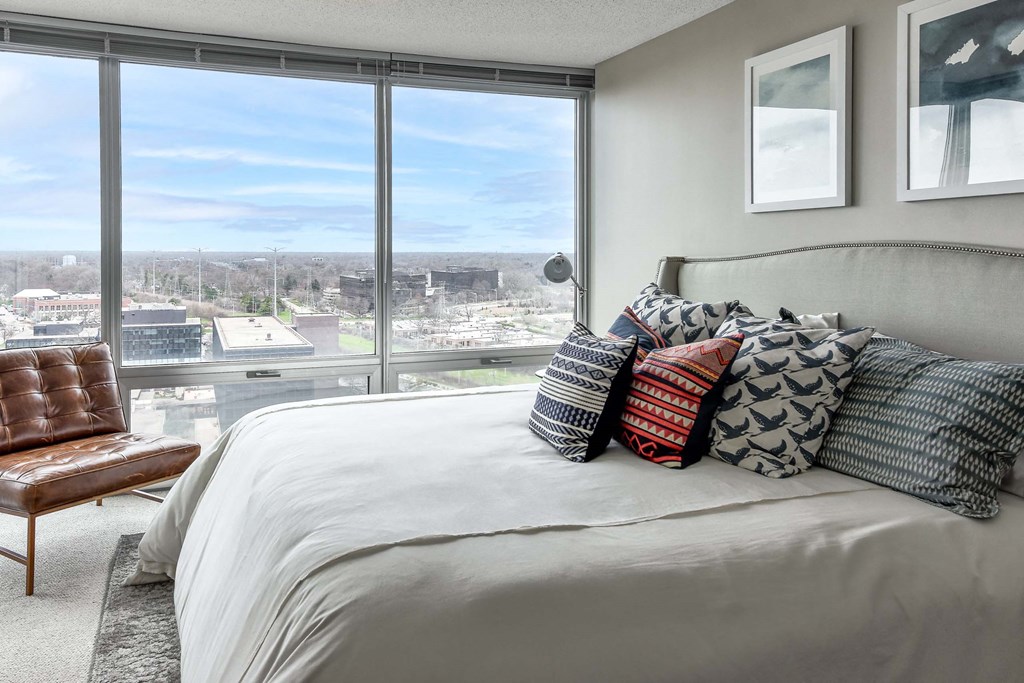 A bedroom with a large bed and a view of the city.