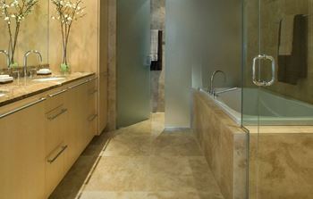 A bathroom with a glass shower stall and a sink with a mirror.