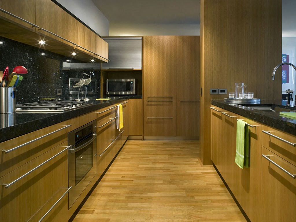 A kitchen with wooden cabinets and a black counter top.