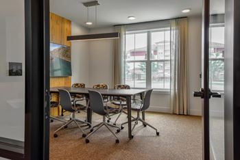 A conference room with a long table and chairs.