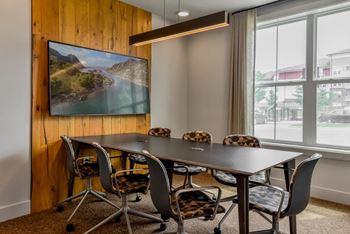 A conference room with a large table and chairs.