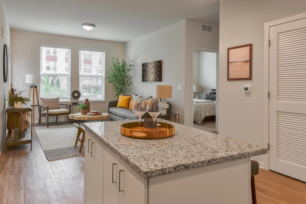 A kitchen with a granite countertop and a dining area with a table and chairs.