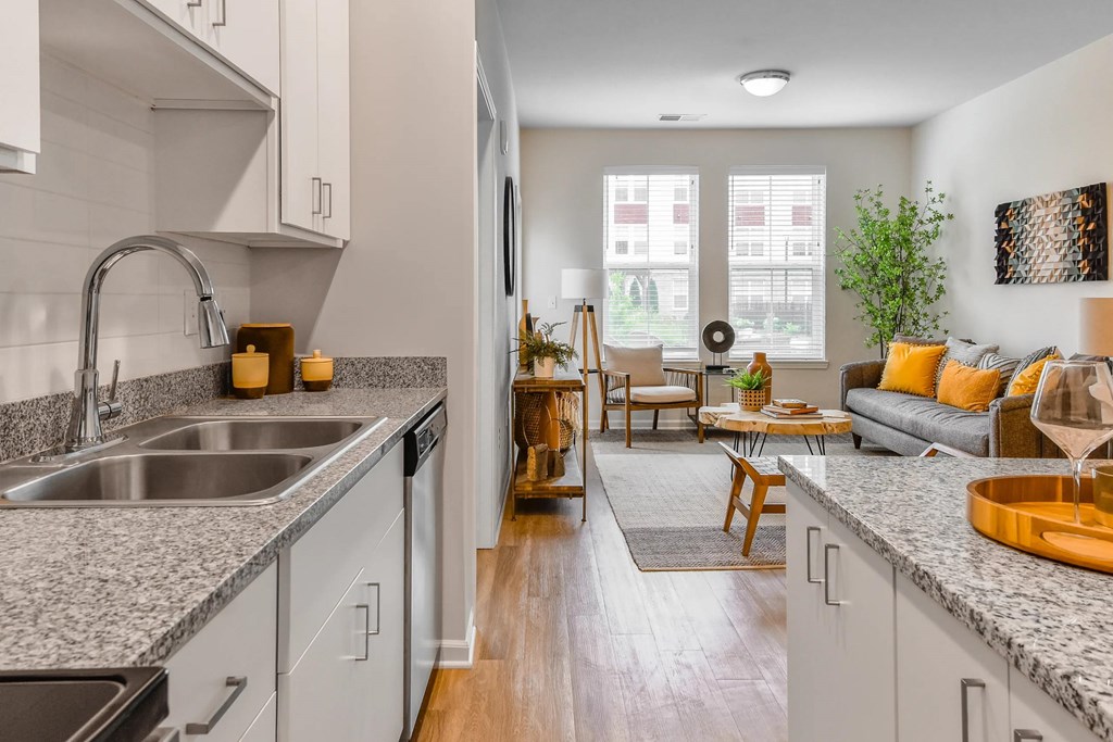 A modern kitchen with a dining area in the background.