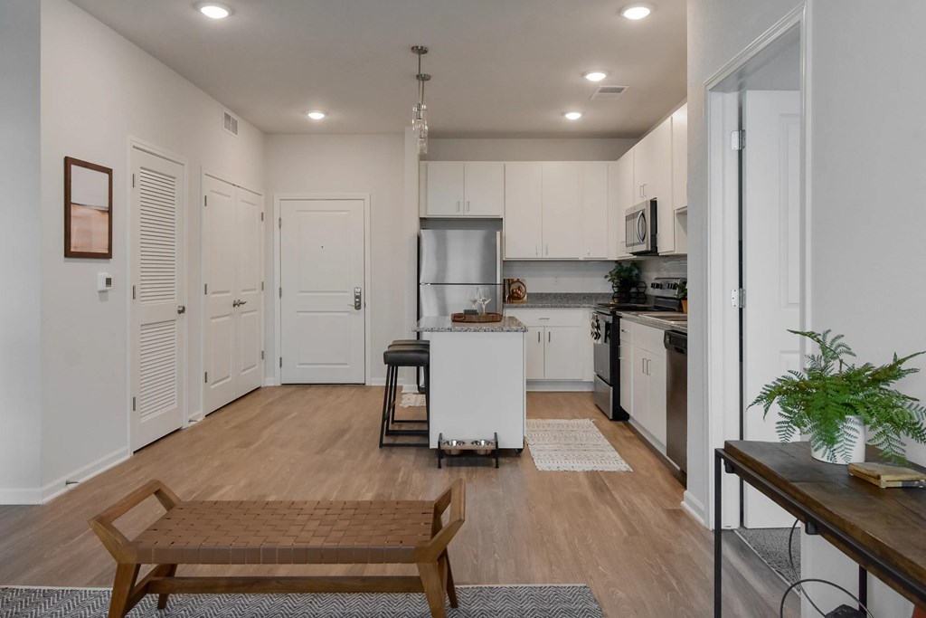 A modern kitchen with a white refrigerator, stove, and oven, and a dining table with chairs.