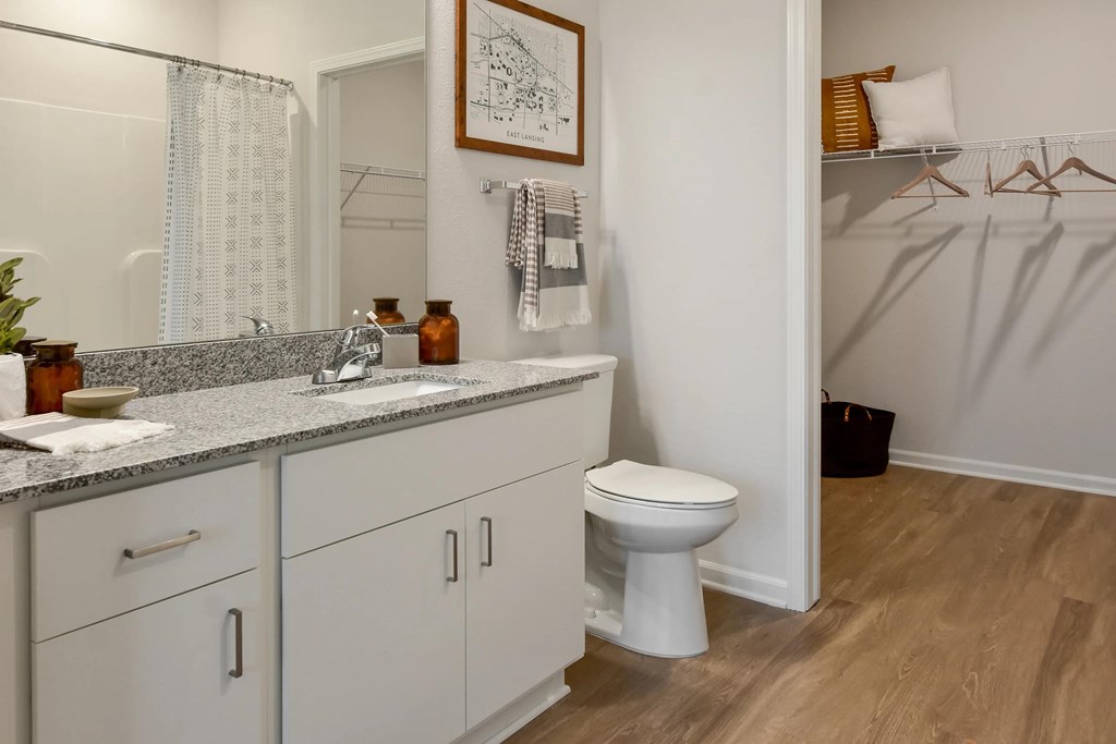 A bathroom with a white toilet, a sink, and a mirror.