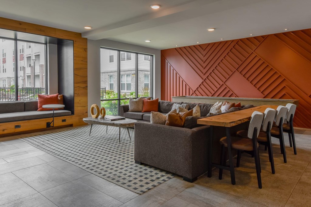 A modern living room with a wooden accent wall and a grey sofa.