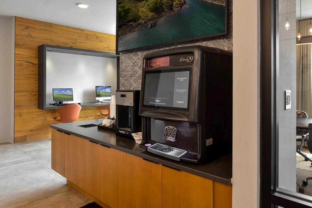 A modern office with a wooden wall and a large screen on the counter.