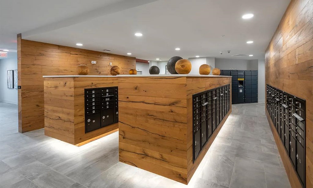 A long hallway with a wooden wall and a black door at the end.