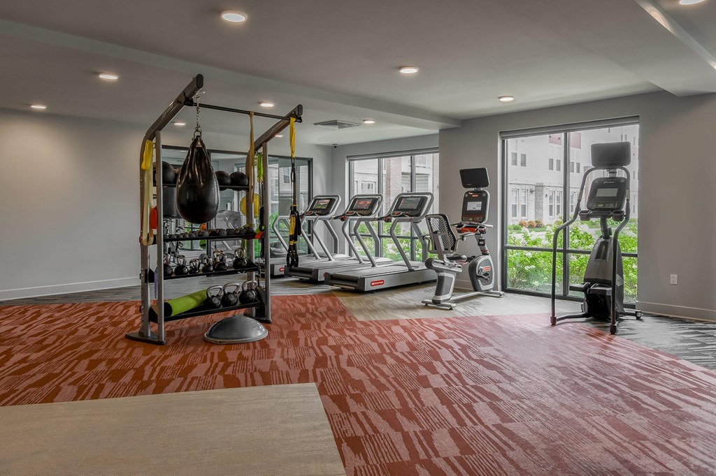 A gym with a red floor and various exercise equipment.