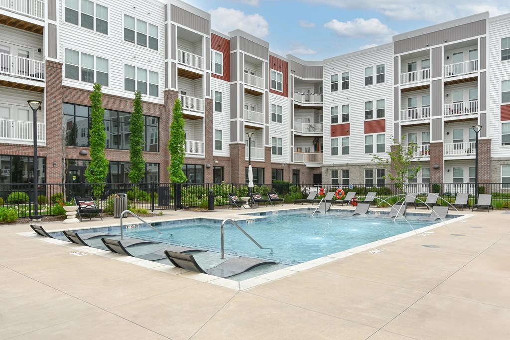 A swimming pool in front of apartment buildings.