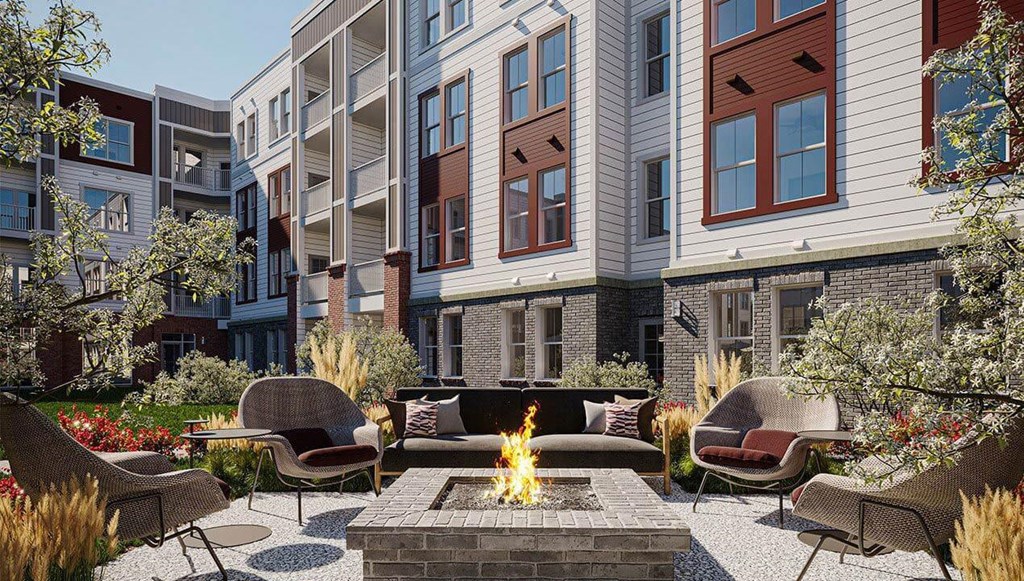 A fire pit sits in the middle of a patio surrounded by chairs and plants.