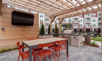 A patio with a table and chairs and a TV on the wall.