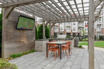 A patio with a table and chairs and a television.