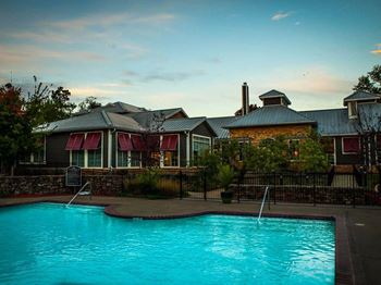 A pool in front of a building with a sign.
