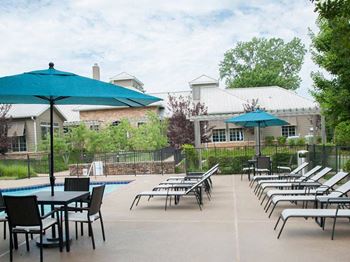 A poolside area with chairs and tables.