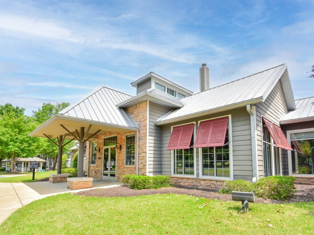 A modern house with a grey exterior and a red awning.