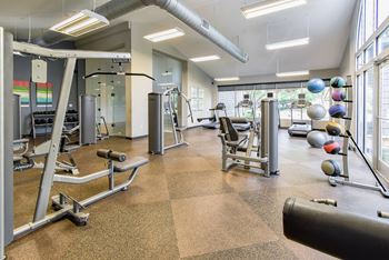 A gym with a variety of equipment including weights and machines.