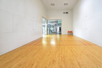 A long empty room with wooden floors and white walls.