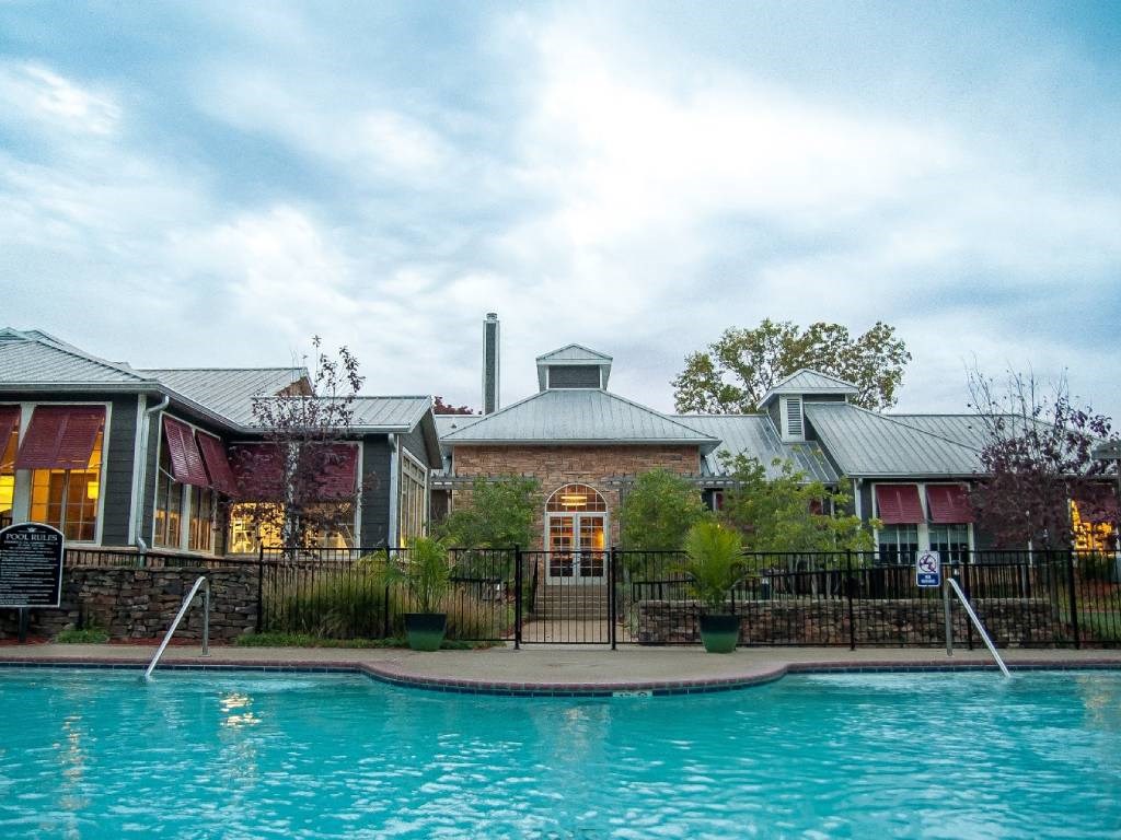 A house with a pool in front of it.