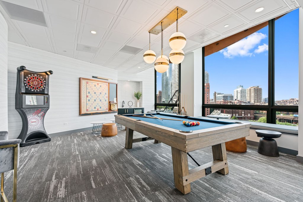 A pool table in a room with a view of the city.