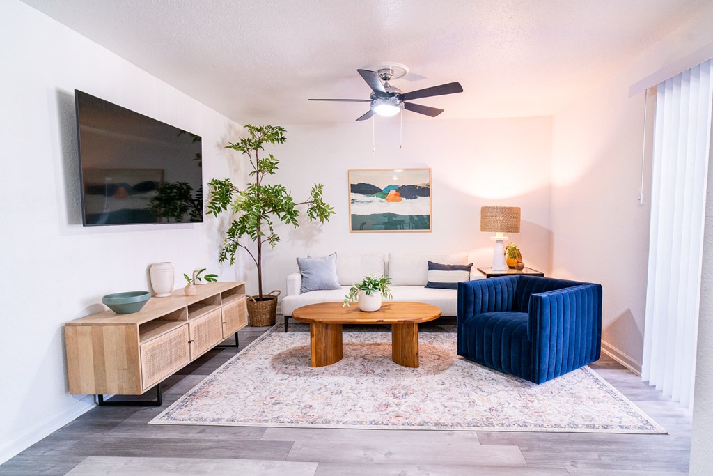 A living room with a blue couch and a wooden coffee table.