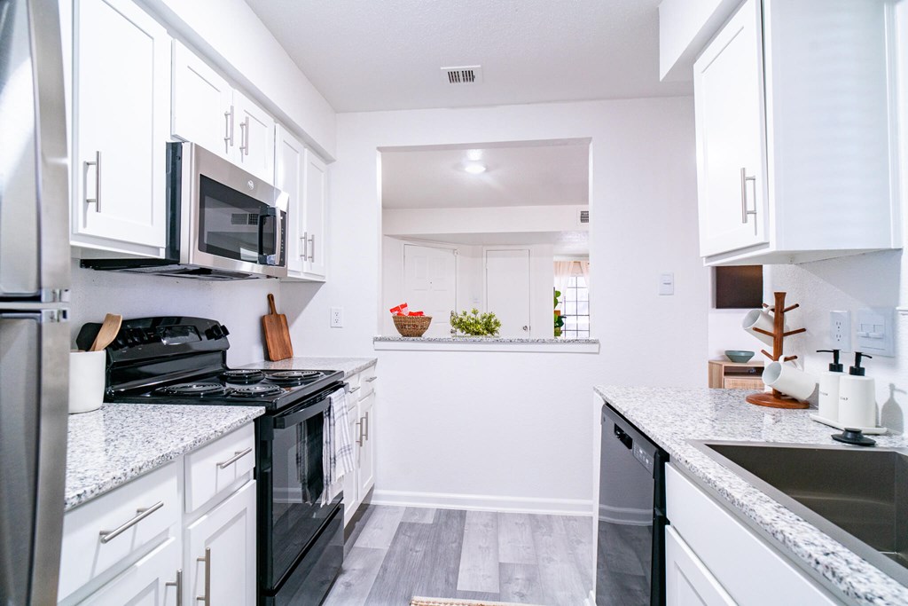 A kitchen with white cabinets and a black stove top oven.