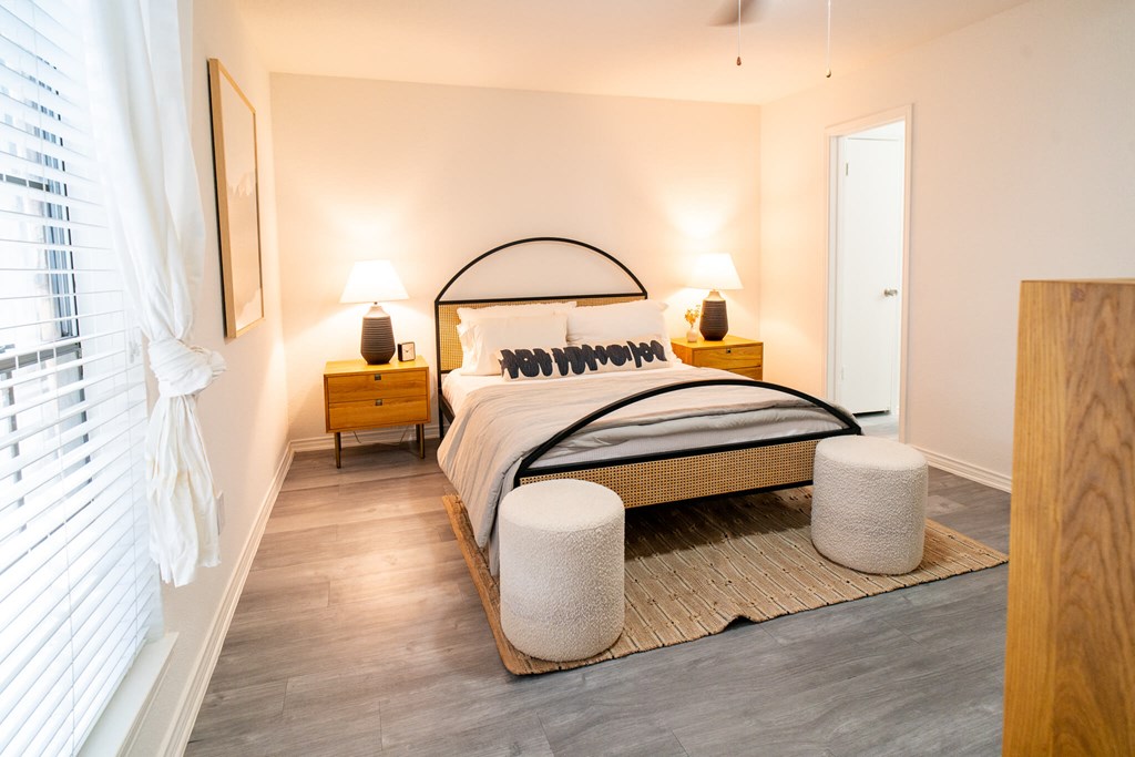 A bedroom with a bed, nightstands, and a rug.