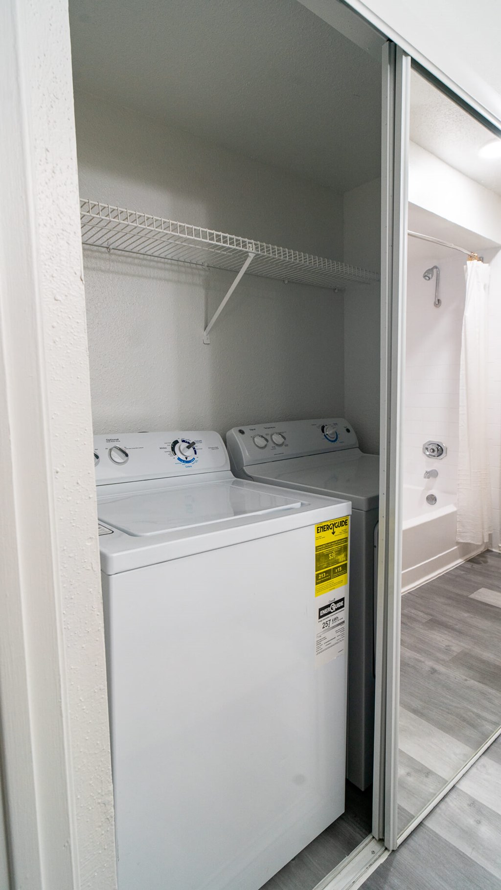 A white dishwasher is in a kitchen with a white door.
