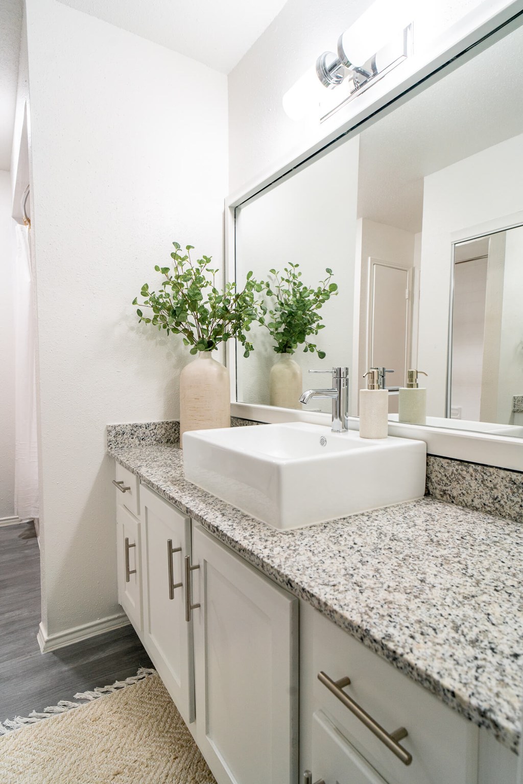 A bathroom with a white sink and a mirror.