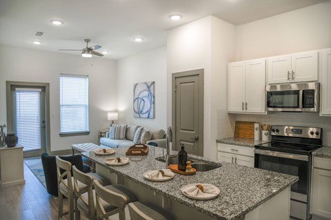 A kitchen with granite countertops and stainless steel appliances.