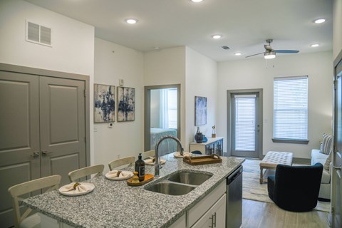 A kitchen with a table and chairs and a sink.