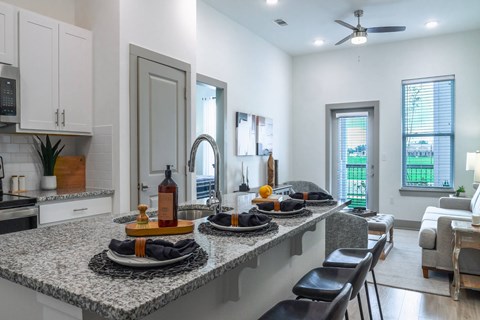 A kitchen with a marble countertop and modern appliances.