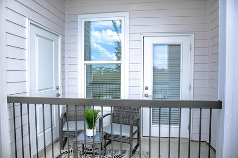 A balcony with a chair and table.