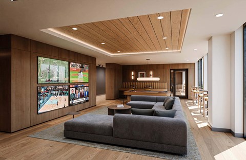 A modern living room with a large grey sofa and a TV screen showing multiple sports events.