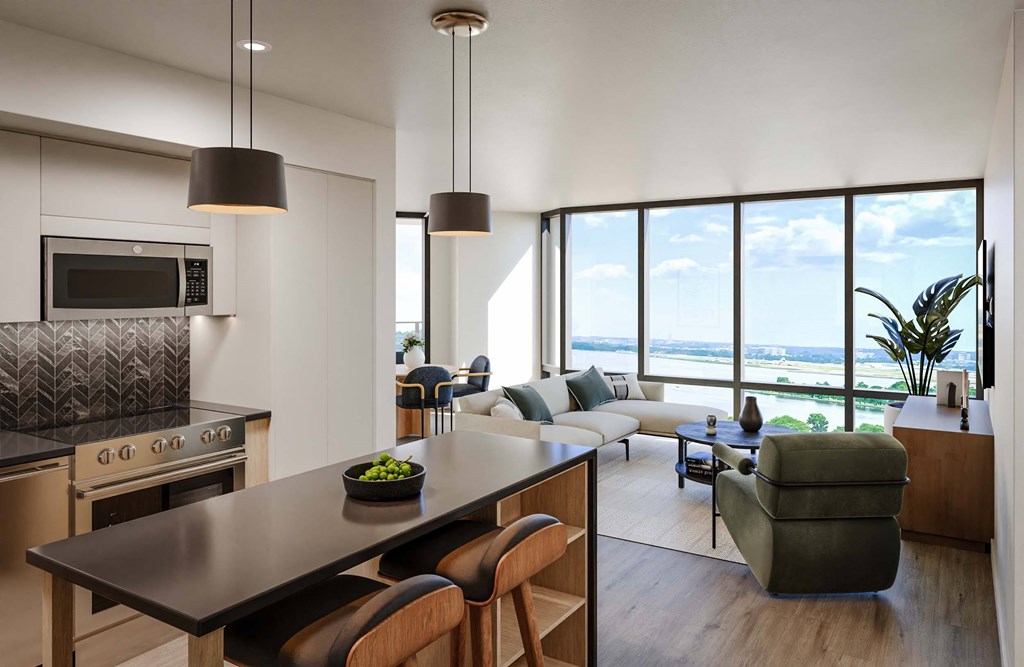 A modern kitchen with a large island and a view of the ocean.