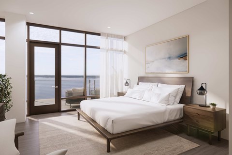 A bedroom with a large bed and a view of the ocean through the window.