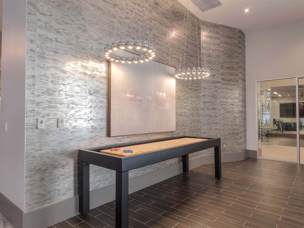A modern dining room with a wooden table and a chandelier.