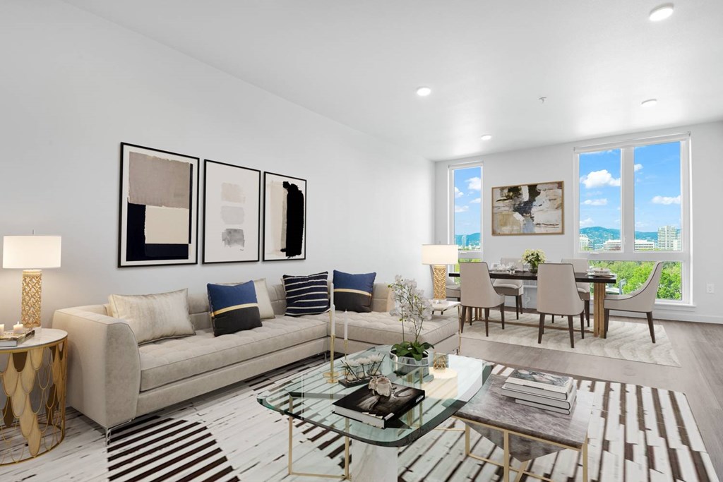 A modern living room with a glass coffee table and a large window.