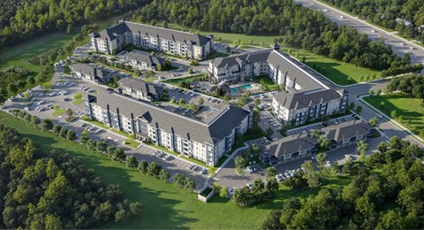 A large, modern building complex surrounded by a green landscape.