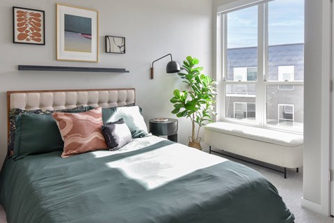 One Bedroom Luxury Apartments in Hopkins, MN - The Hallon - Furnished Bedroom with Plush Carpet Flooring and an Oversized Window