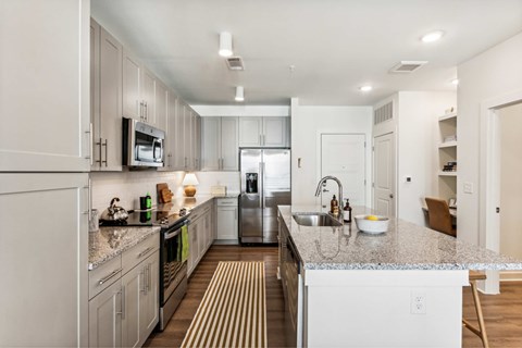 A modern kitchen with a granite countertop and stainless steel appliances.