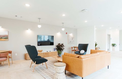 A living room with a black chair and a yellow sofa.