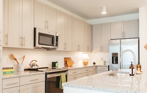 A kitchen with white cabinets and a granite countertop.
